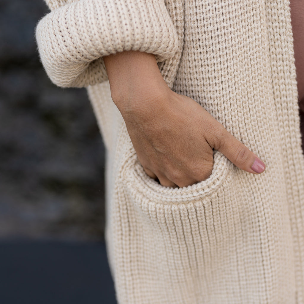 Woman's hand in cozy sweater pocket. Sakti Rising Dhumavati Cardigan, ethical sustainable apparel.