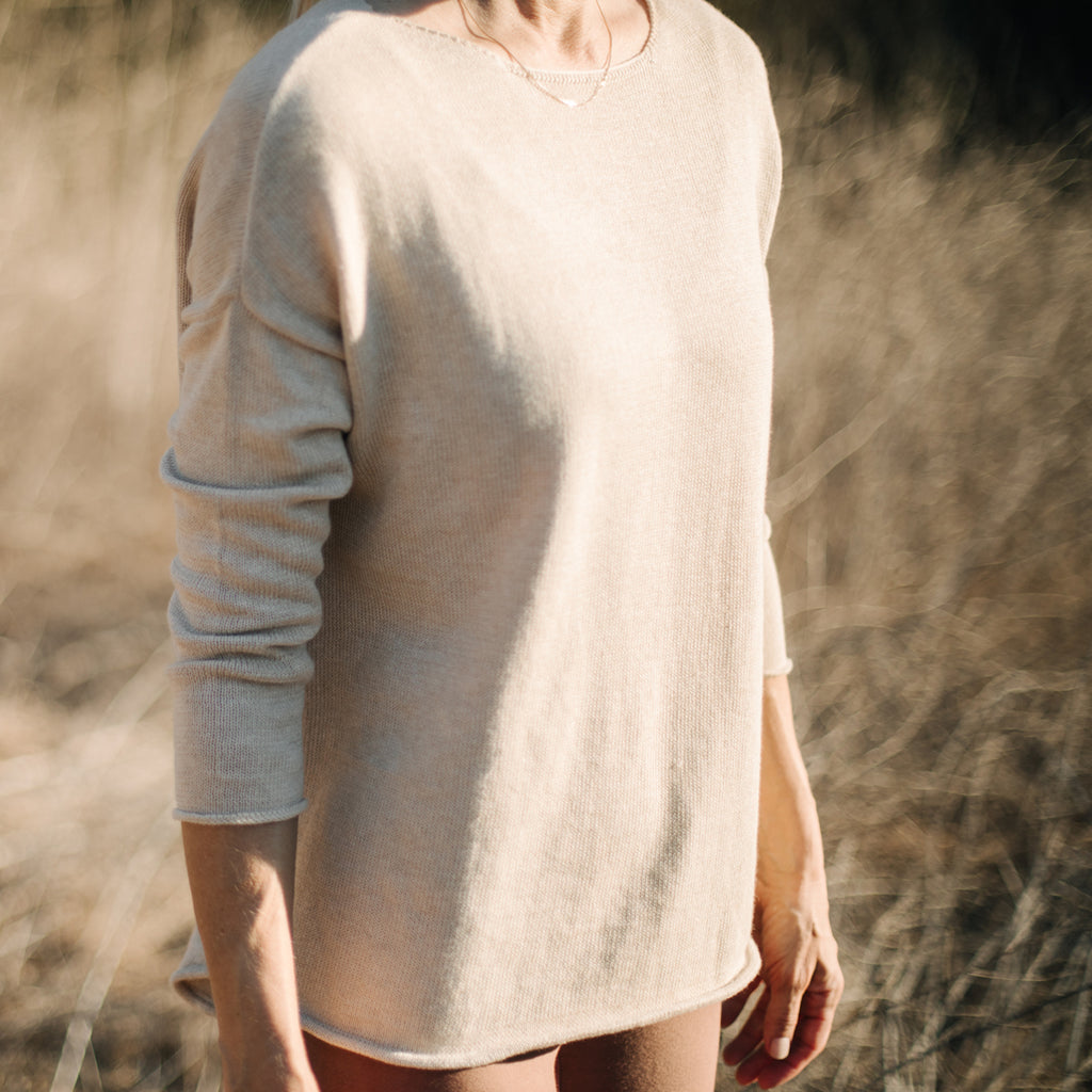 Closeup of woman's torso, wearing Sakti Rising Matangi Sweater in Oat. Ethical Sustainable yoga apparel.