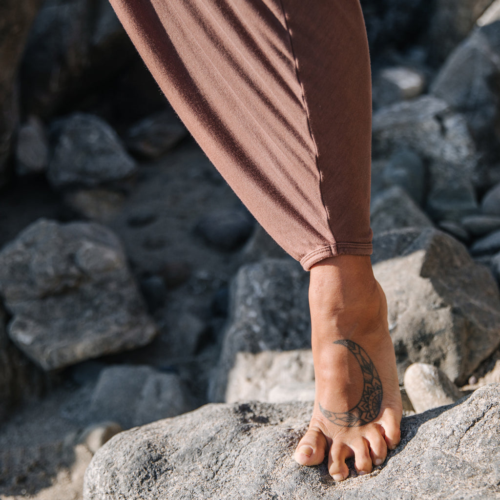 Closeup of woman's foot with moon tattoo, wearing Sakti Rising Parvati Pant in Cacao. Ethical sustainable yoga apparel. 