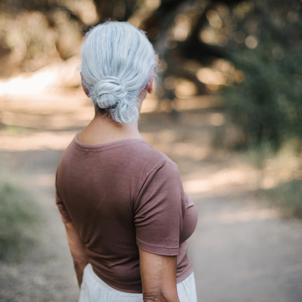 Woman with white hair wearing Sakti Rising Tara Tee in Cacao. Ethical sustainable yoga apparel.