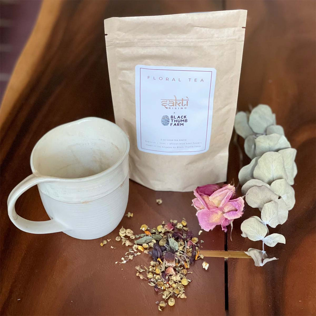 Sakti Rising by Black Thumb Farms calming herbal tea blend. Tea bag shown with mug and dried herbal ingredients. Made in Los Angeles.